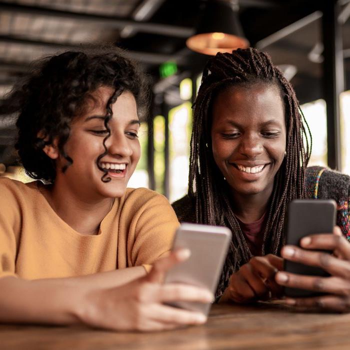 A young woman sends money to her friend using Zelle on the Patelco Mobile App.